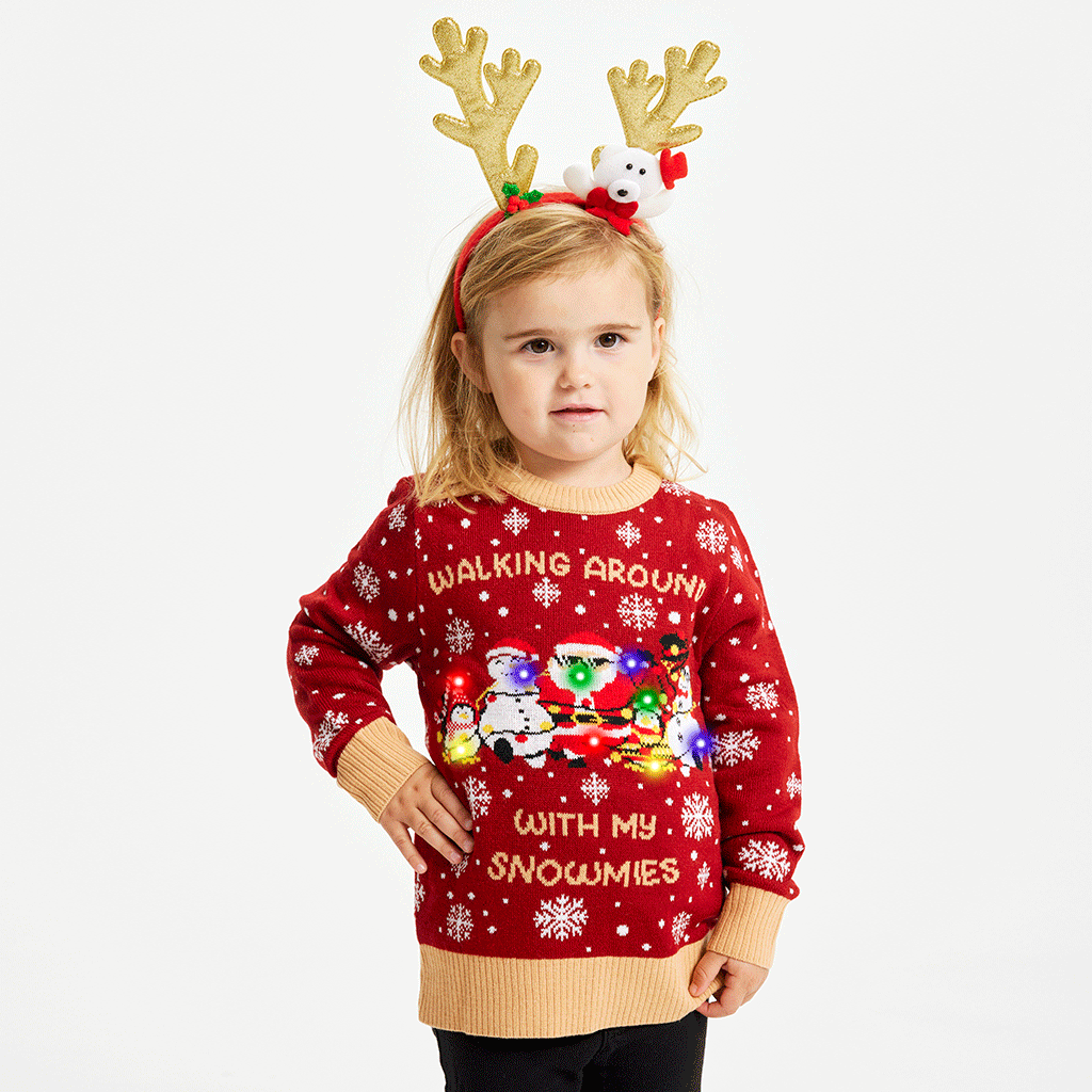 Un simpatico bambino che indossa un maglione natalizio rosso con la citazione